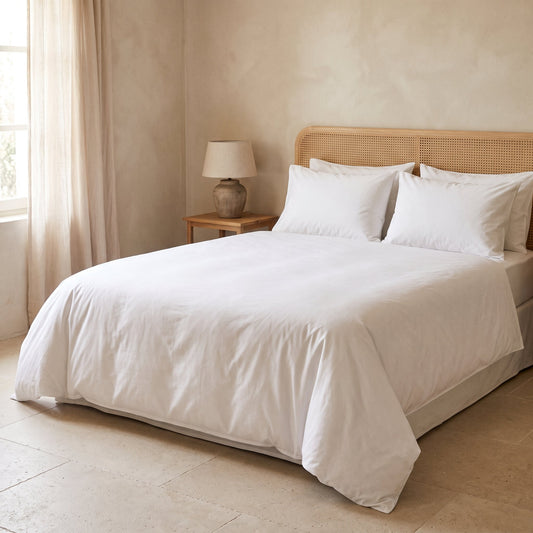 Cama de apartamento turístico con sábanas de percal lisas: sábanas que no se arrugan sin planchar